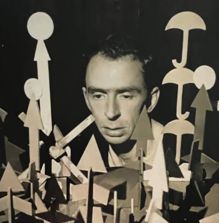 A monochromatic image featuring a man with a serious expression surrounded by abstract geometric shapes, including arrows, circles, and umbrellas, arranged in the foreground.