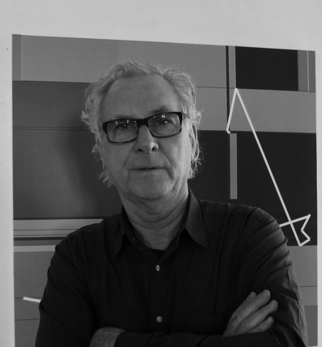 Portrait of an older man with glasses standing in front of abstract art.