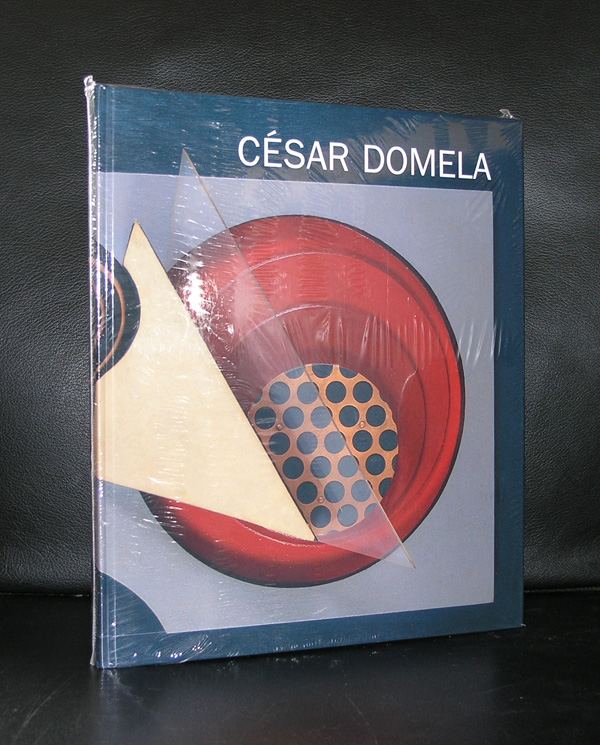 A book titled 'César Domela' with a colorful cover featuring geometric shapes, set against a dark background.