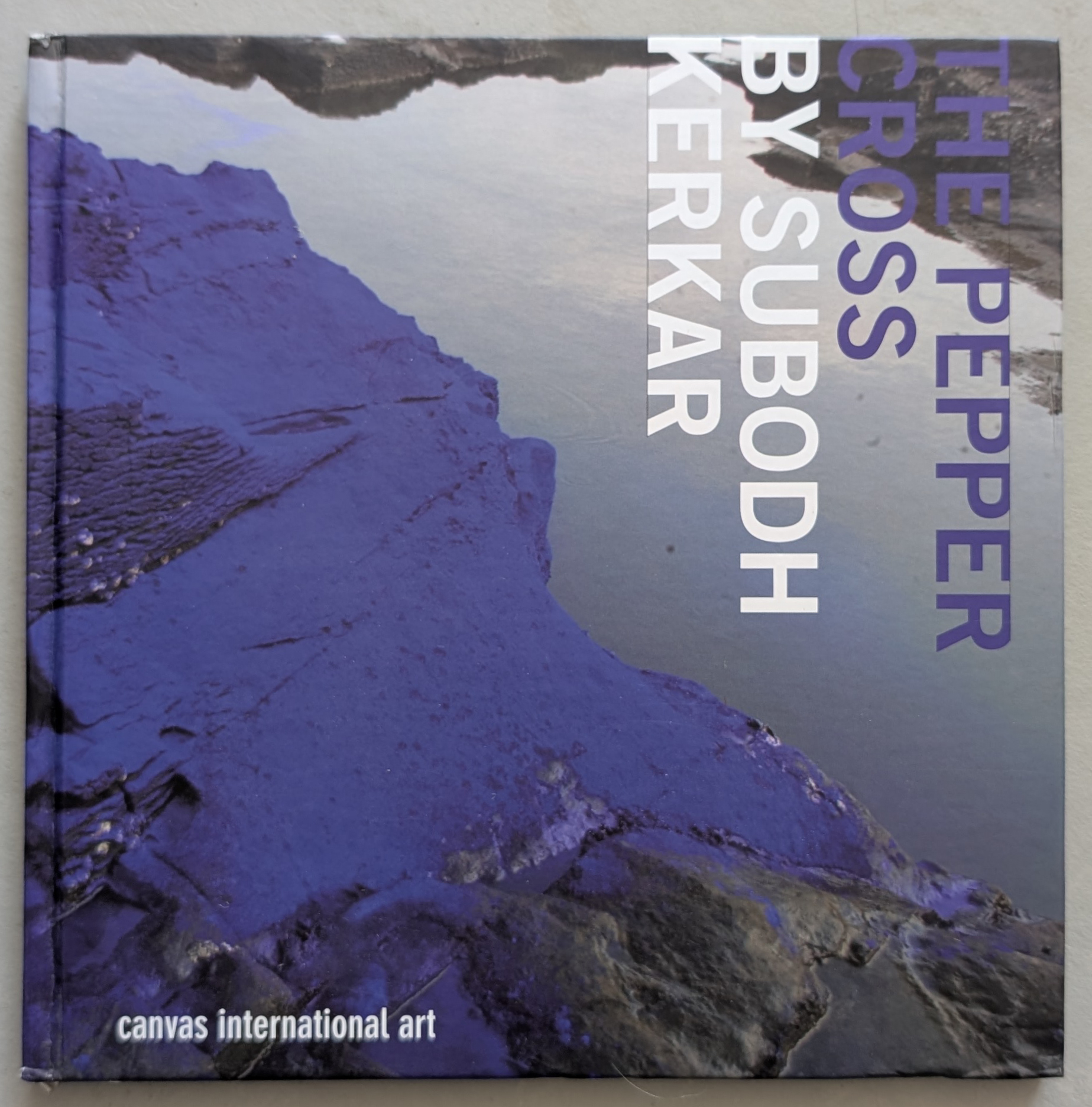Cover of 'The Pepper Cross' by Subodh Kerkar, featuring a purple and grey textured surface with reflections.
