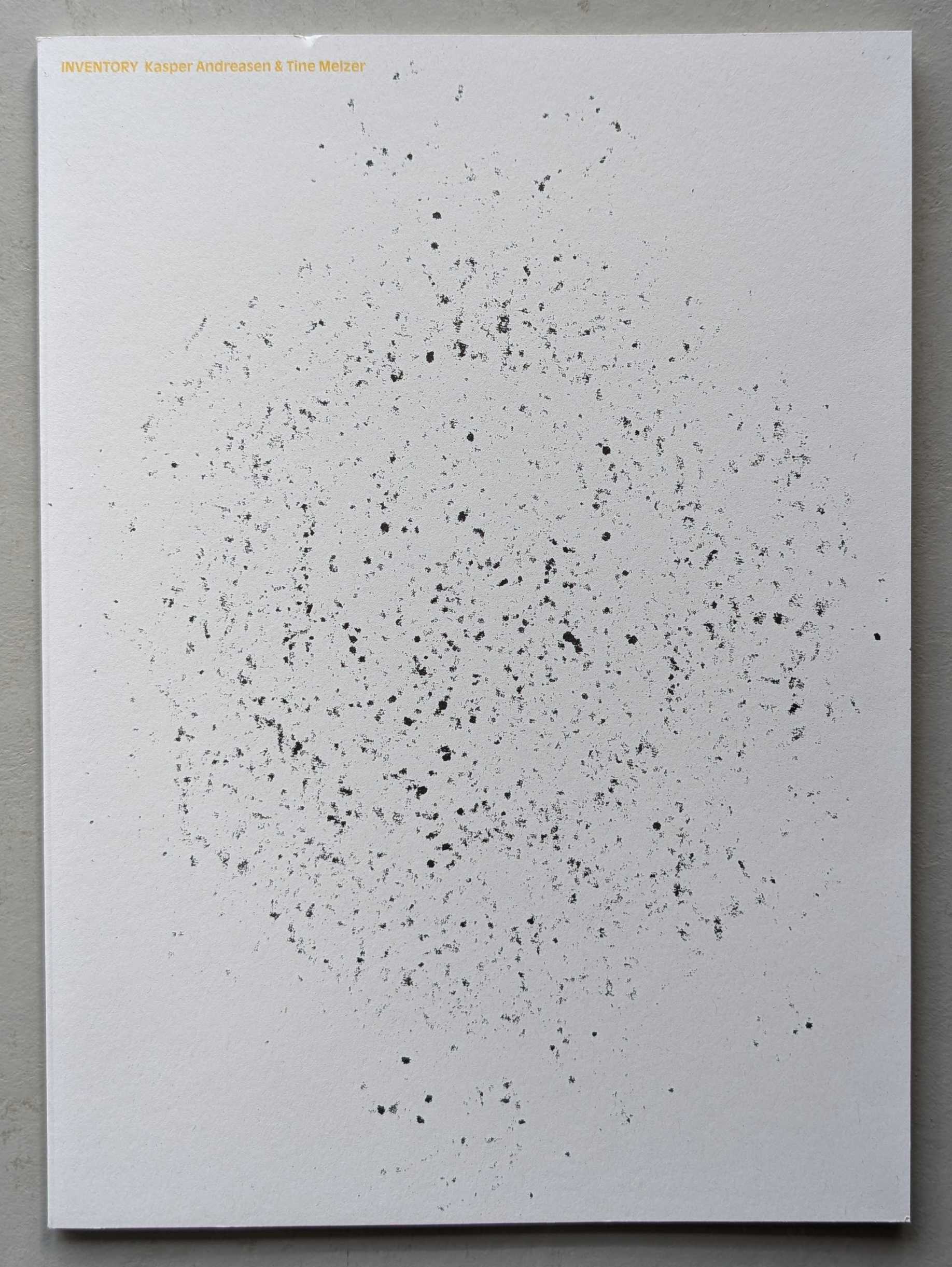 Cover of the artist book titled 'INVENTORY' by Kasper Andreasen and Tine Melzer, featuring a sparse design with scattered black specks on a white background.