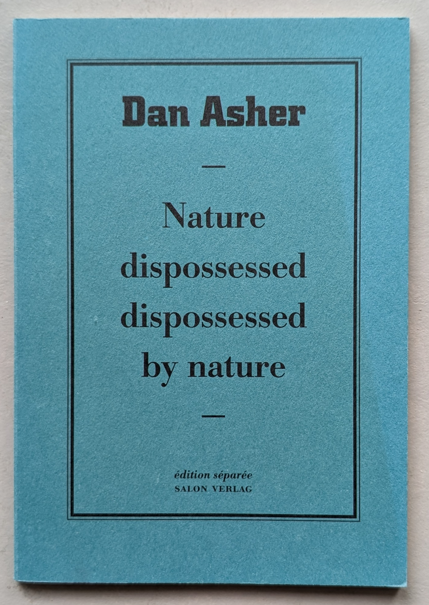A turquoise artist book cover by Dan Asher titled 'Nature dispossessed dispossessed by nature' with black text and simple design.