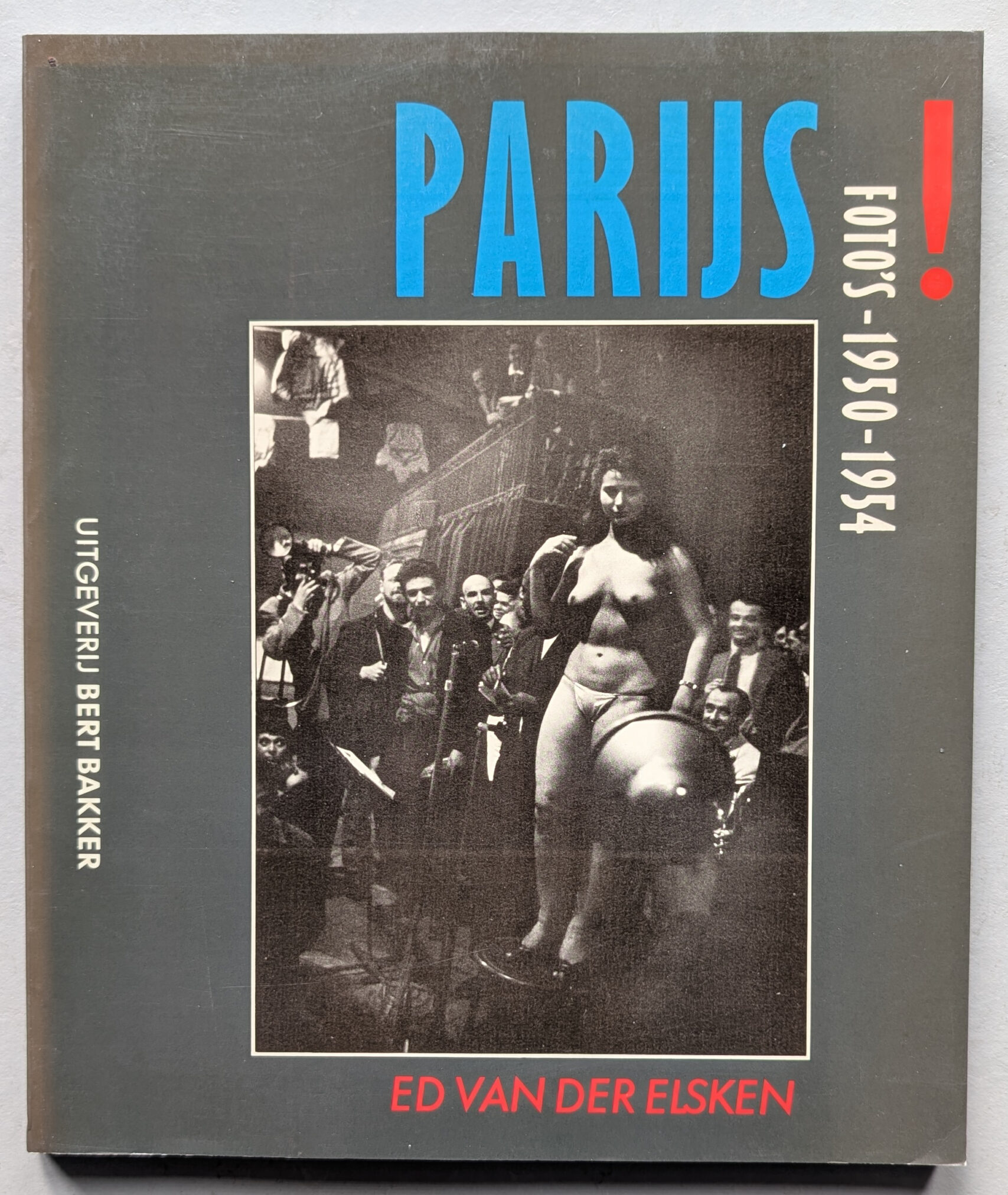 Cover of the book 'PARIJS! Foto's 1950-1954' by Ed van der Elsken, featuring a bold title in blue and a black and white image of a woman performing on stage surrounded by a crowd.
