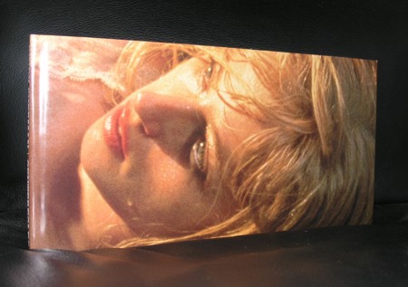 A close-up view of a book cover featuring a woman's face with soft features, partially covered by hair, set against a warm, blurred background.