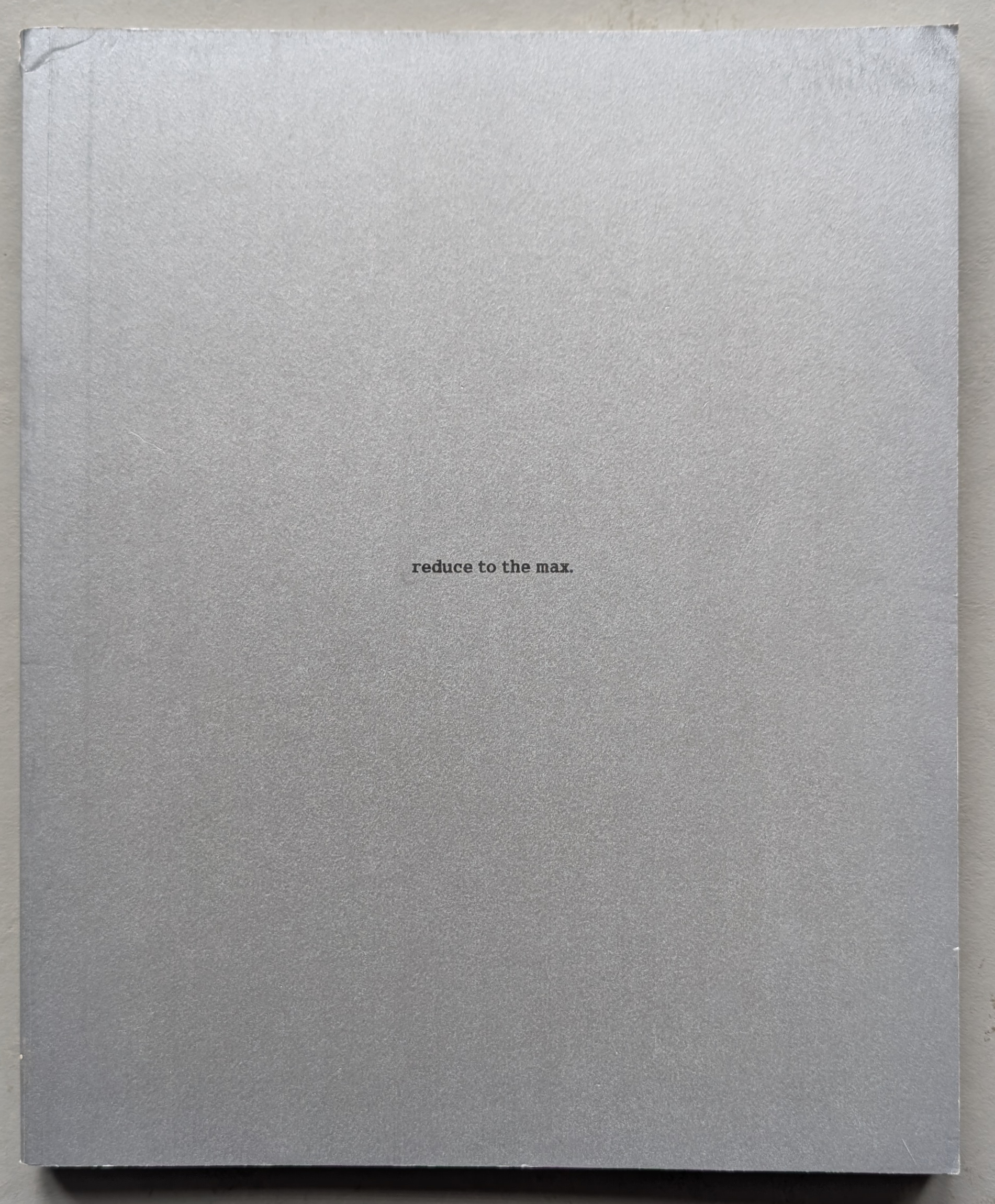 A minimalist silver book cover with the text 'reduce to the max.' centered on the front.