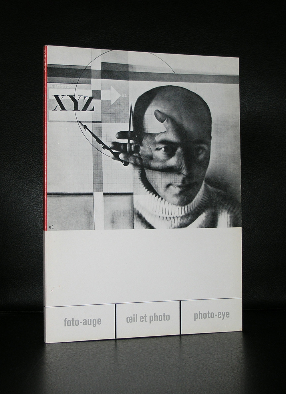 A magazine cover featuring a stylized black and white portrait of a person with a hand holding a compass, alongside geometric patterns and the text 'XYZ'.